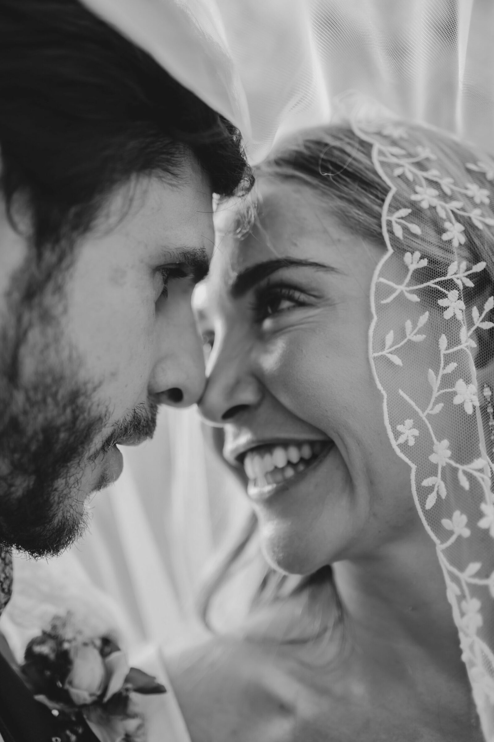 Photographe mariage Flayosc 7 En noir et blanc, les mariés front contre front, la mariée sourit sous son voile en dentelle