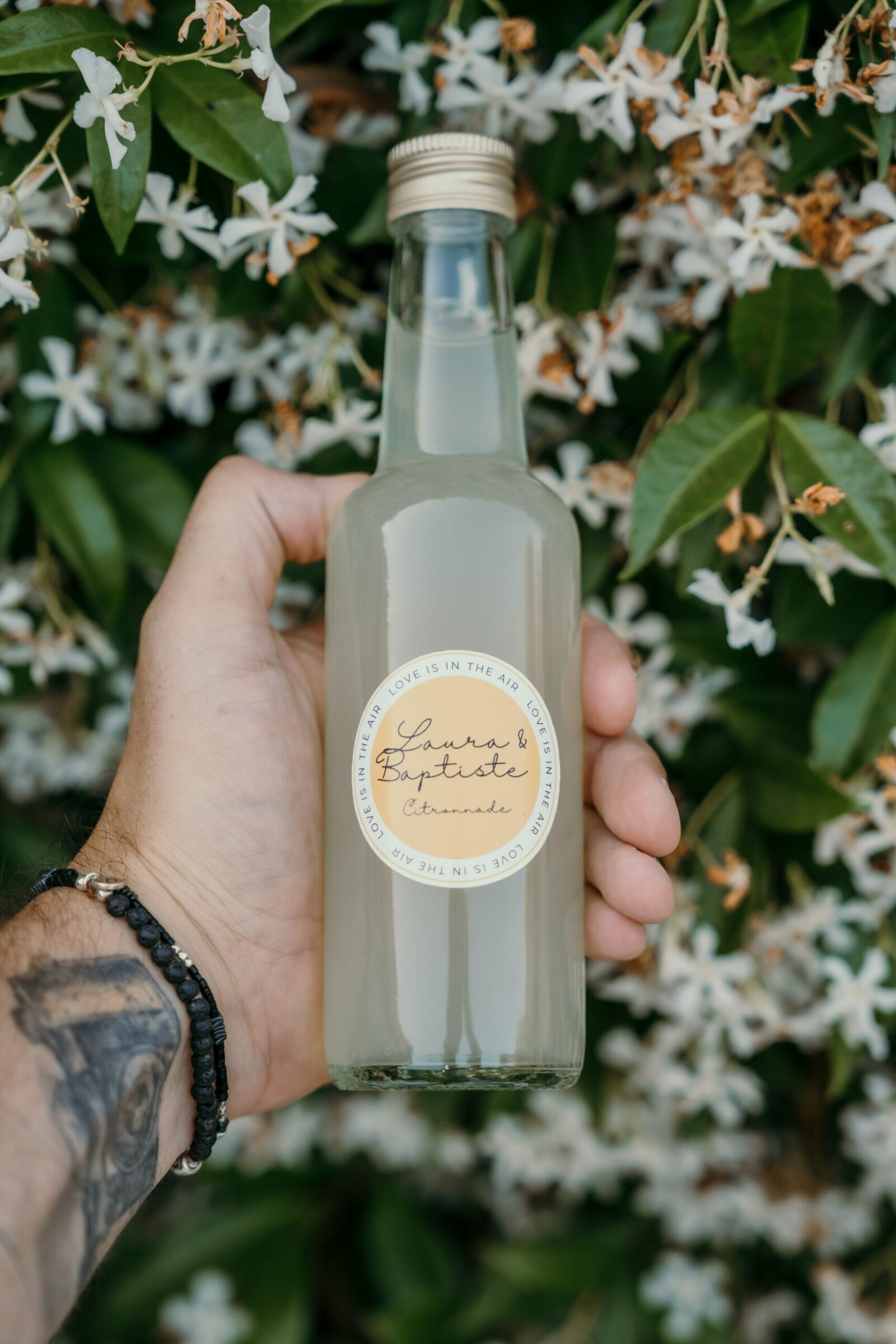 Photographe mariage Cogolin 7 Une bouteille de limonade personnalisée tenue au milieu des fleurs de jasmin