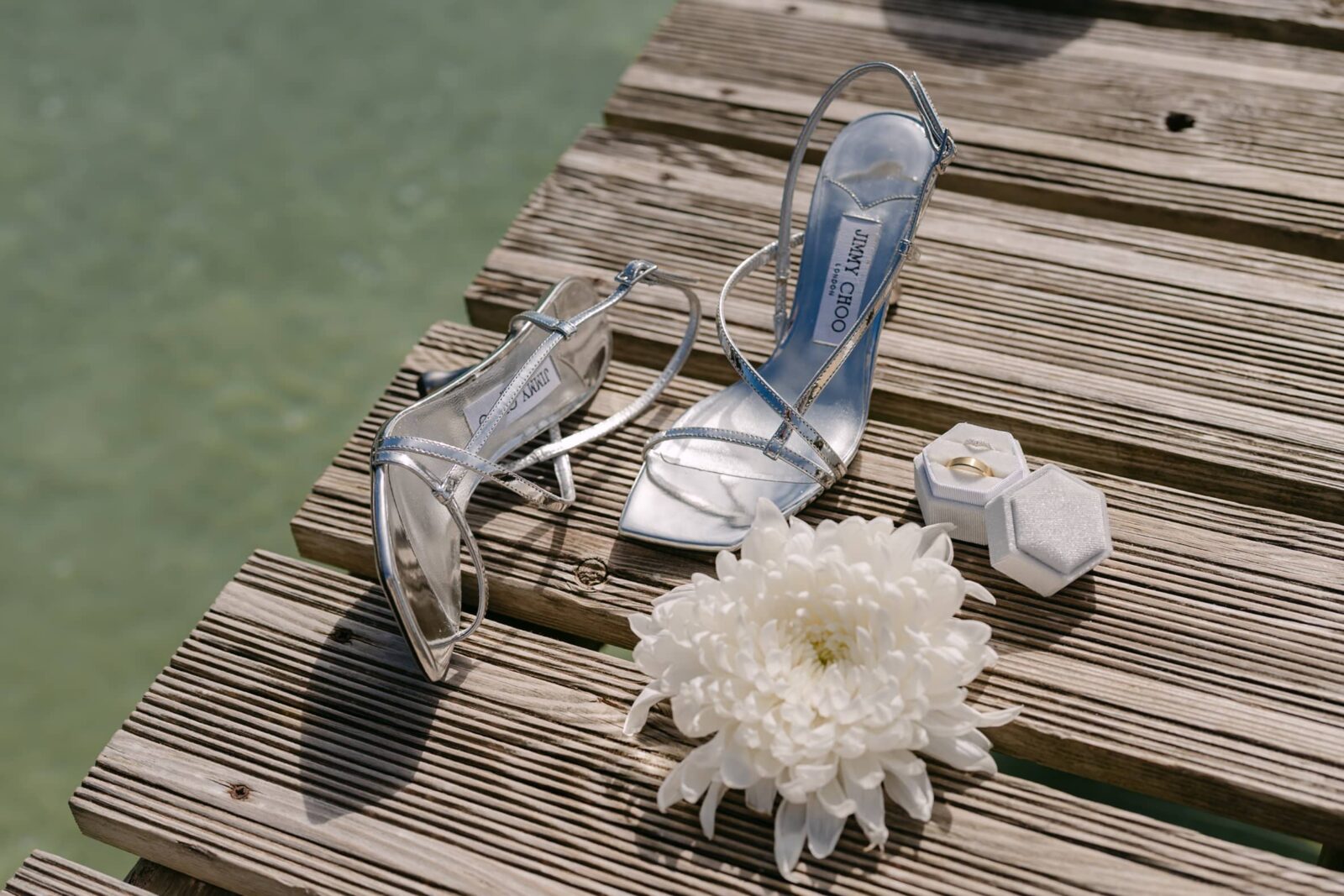 Photographe mariage Gassin 8 Les chaussures argentées de la mariée et une fleur blanche sur un ponton en bois