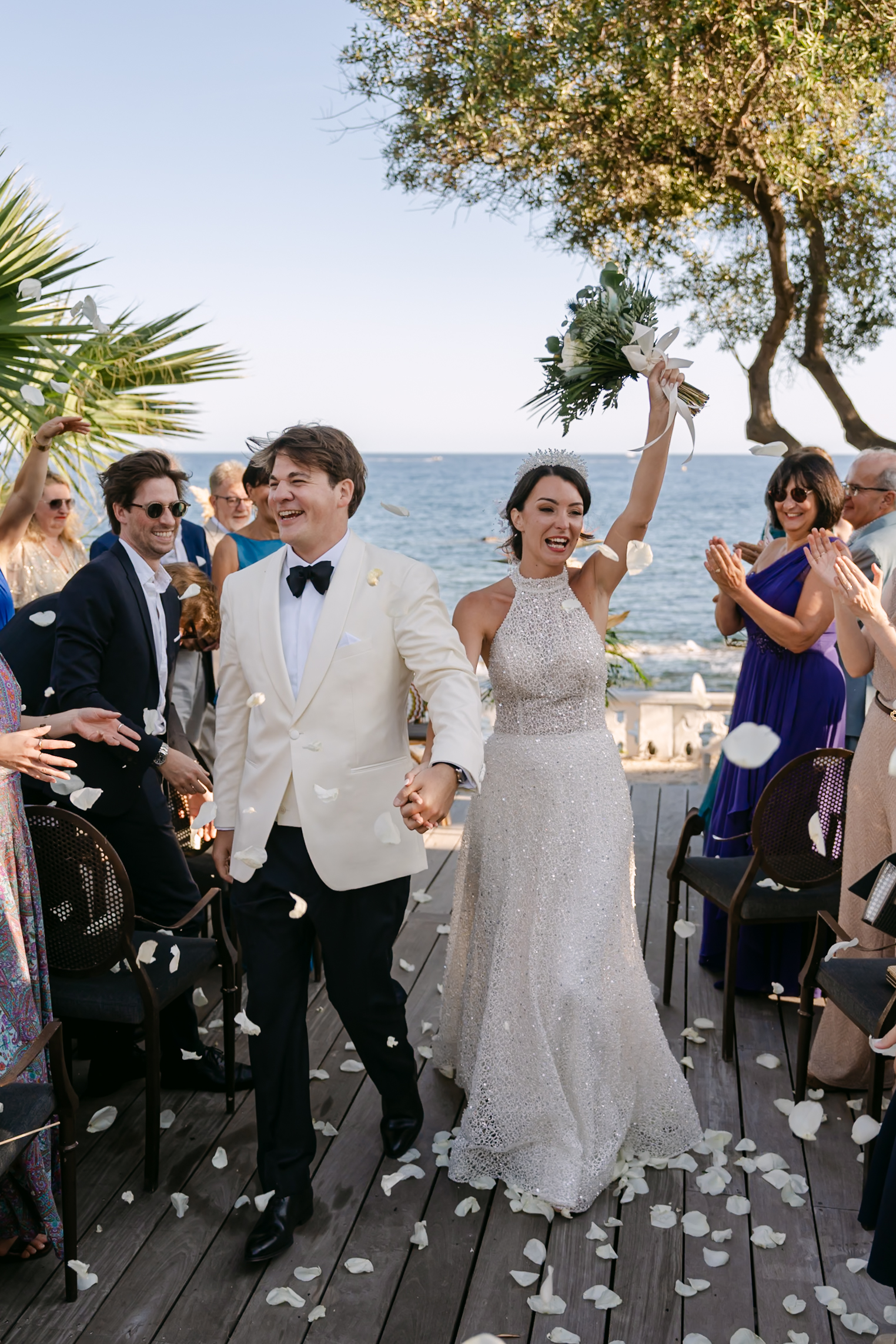 Photographe mariage Fréjus 5 Les mariés remontent l'allée en riant sous les pétales, au bord de la mer