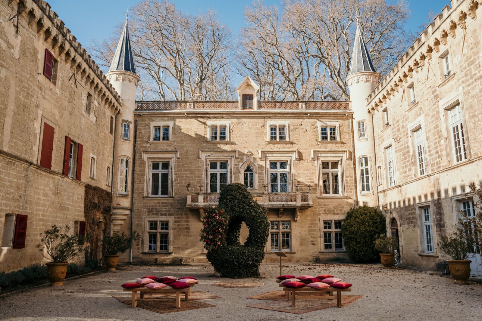 Photographe mariage château Provence 2 La cour d'un château en pierre et ses tourelles, sous les platanes