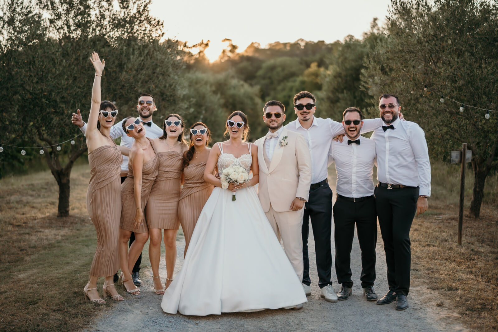 Les photos de groupe au mariage : une liste, et tout va plus vite 1 Les mariés et leurs témoins posent en riant dans une allée d'oliviers