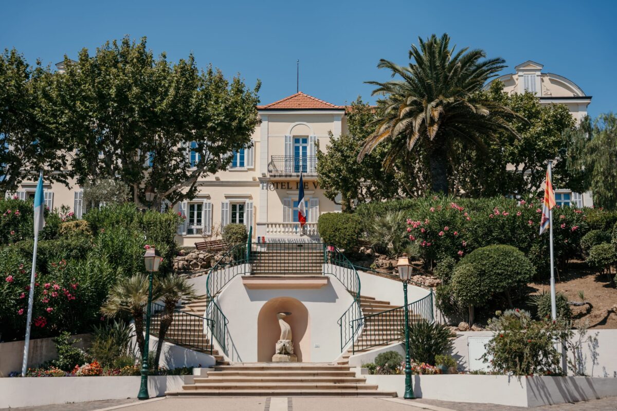 Le grand escalier d'une bastide entourée de palmiers et de jardins
