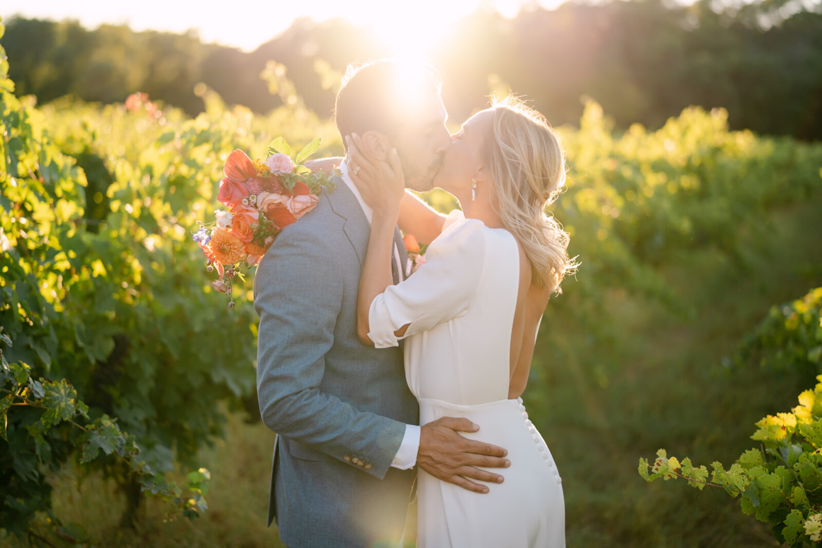 Photographe mariage Les Arcs 3 Les mariés s'embrassent au milieu des vignes, à contre-jour