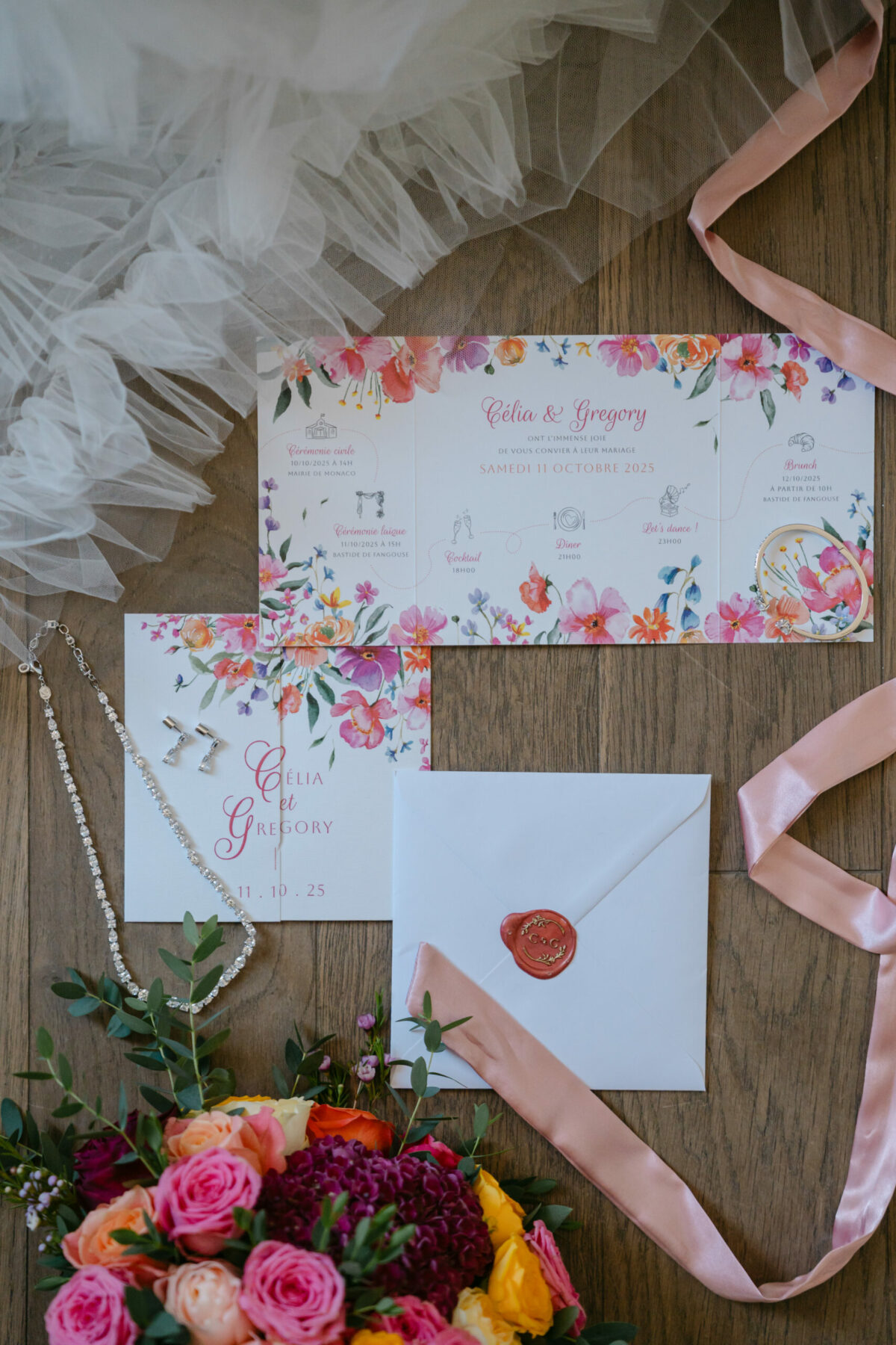 Faire-part à l'aquarelle, ruban rose et bouquet coloré sur une table en bois