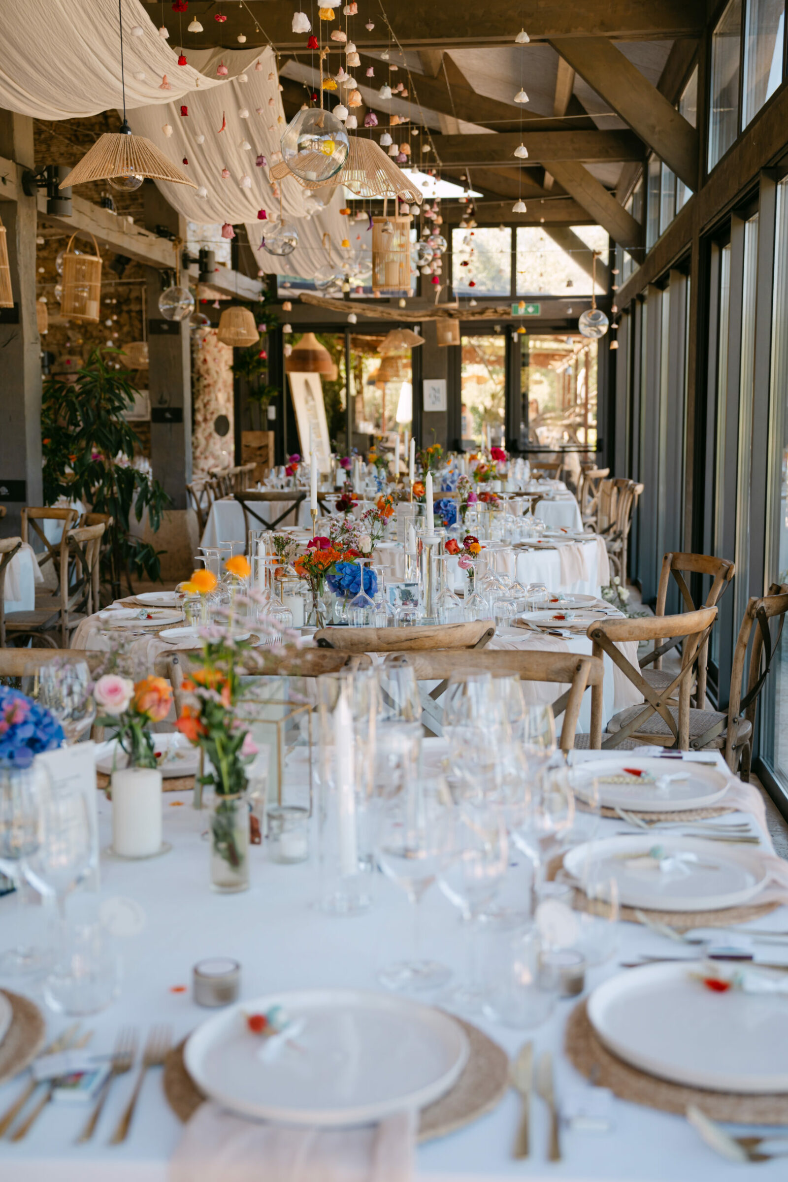 Photographe mariage Gassin 5 Longue table dressée sous une halle en bois, fleurs colorées et voilages