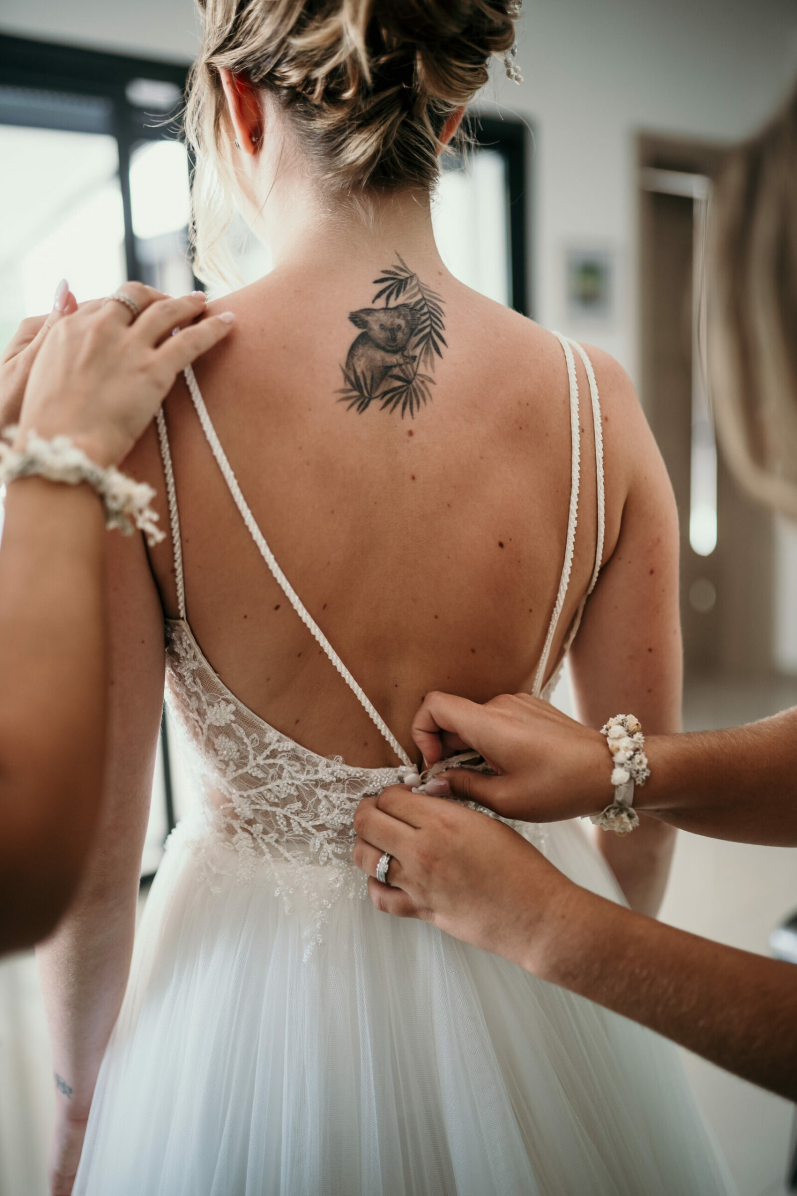 Photographe mariage Sainte-Maxime 7 Une proche lace le dos de la robe de la mariée