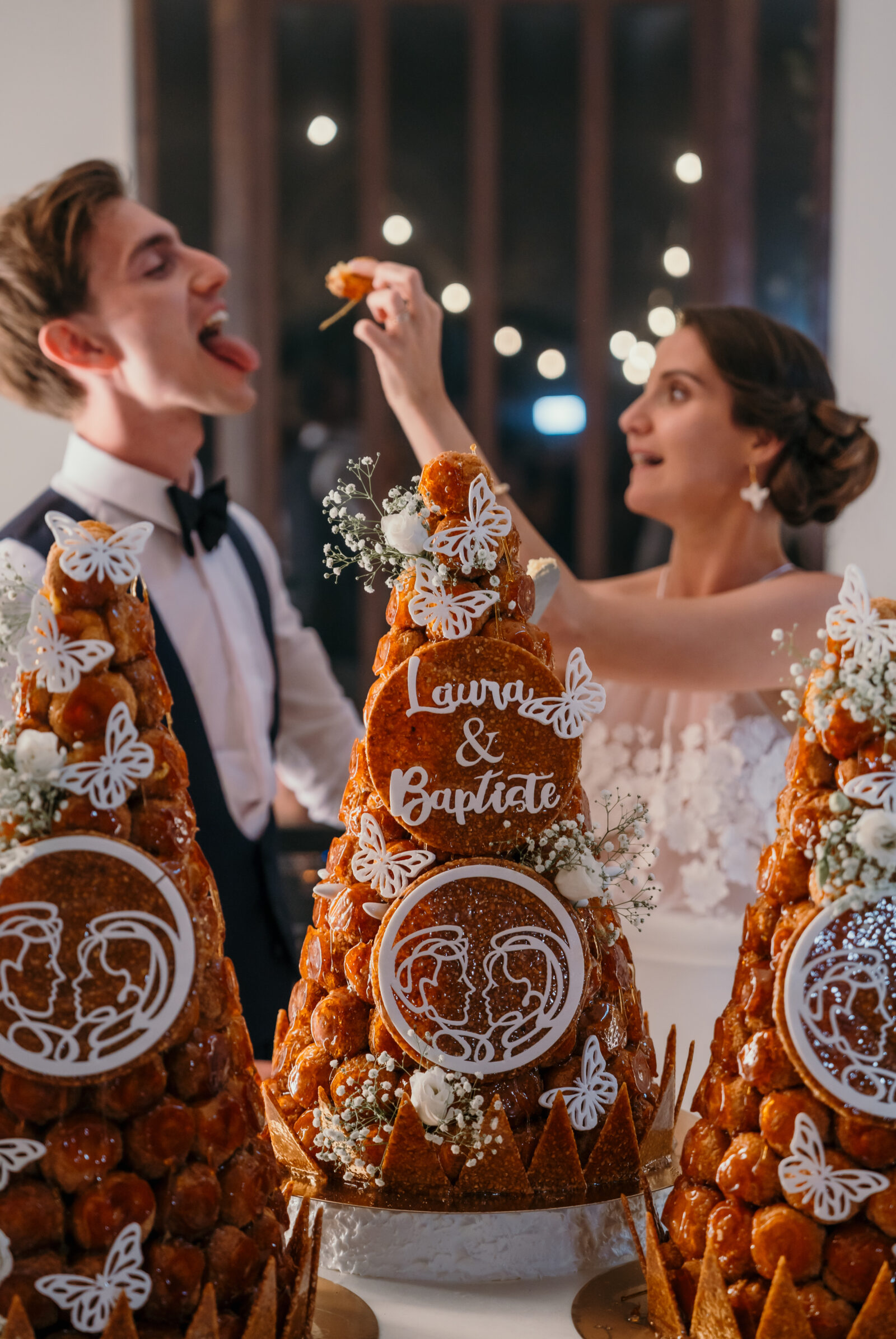 Accueil 20 Le marié tire la langue pendant que la mariée lui tend un chou de la pièce montée