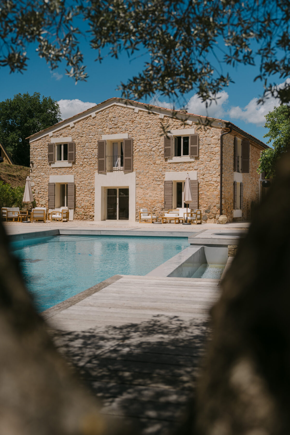 Accueil 100 Une bastide en pierre et sa piscine, vues à travers le feuillage