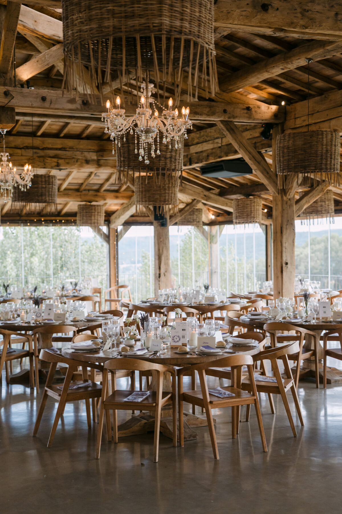 Accueil 99 Grande halle en bois ouverte sur le paysage, tables dressées et lustre en cristal