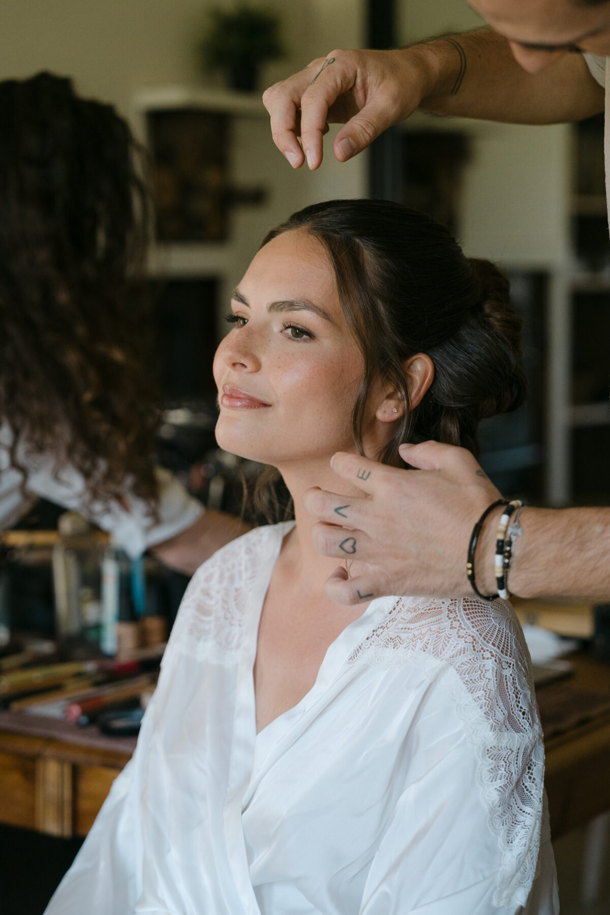 Accueil 15 La mariée en peignoir, les yeux mi-clos, pendant qu'on termine sa coiffure