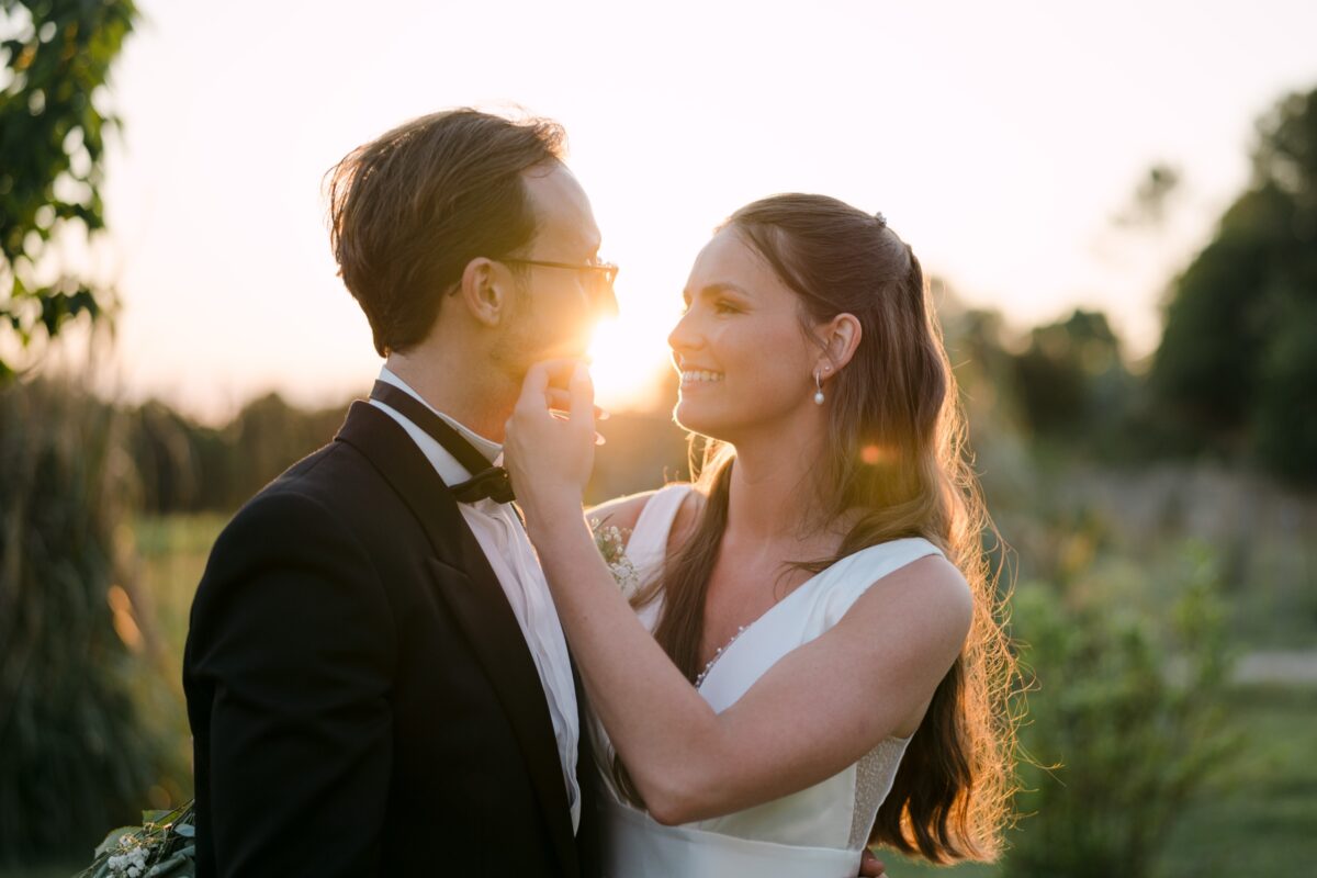 Le meilleur moment pour les photos de couple, le jour du mariage 7 Au soleil couchant, la mariée pose la main sur la joue du marié, ils se sourient