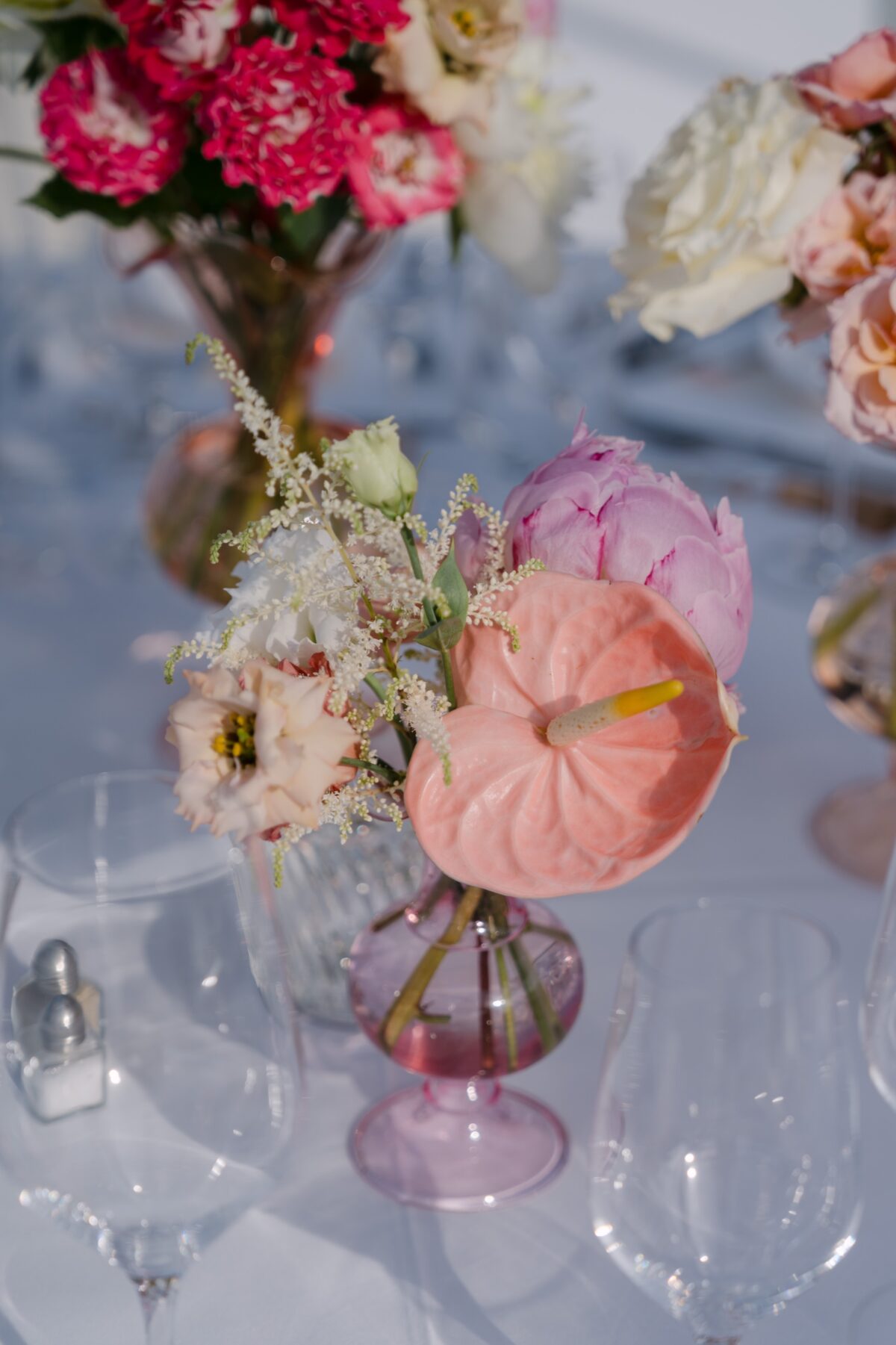 Composition de fleurs roses et rouges sur une table, la mer floue en arrière-plan