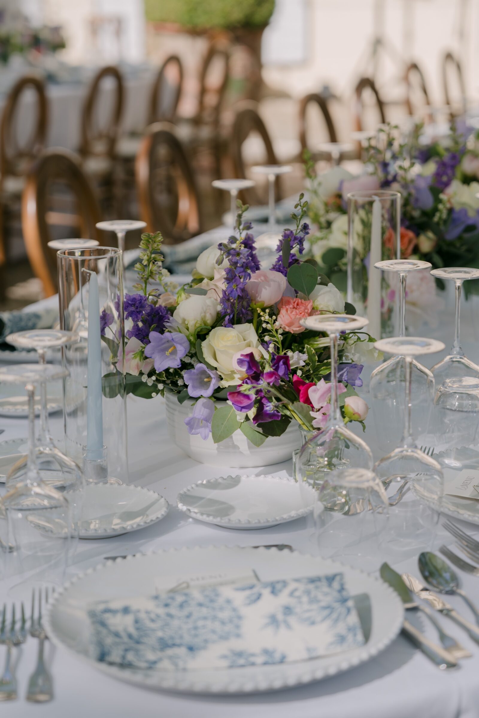 Accueil 12 Table de mariage dressée avec de la vaisselle à motifs bleus et des bouquets de fleurs mauves