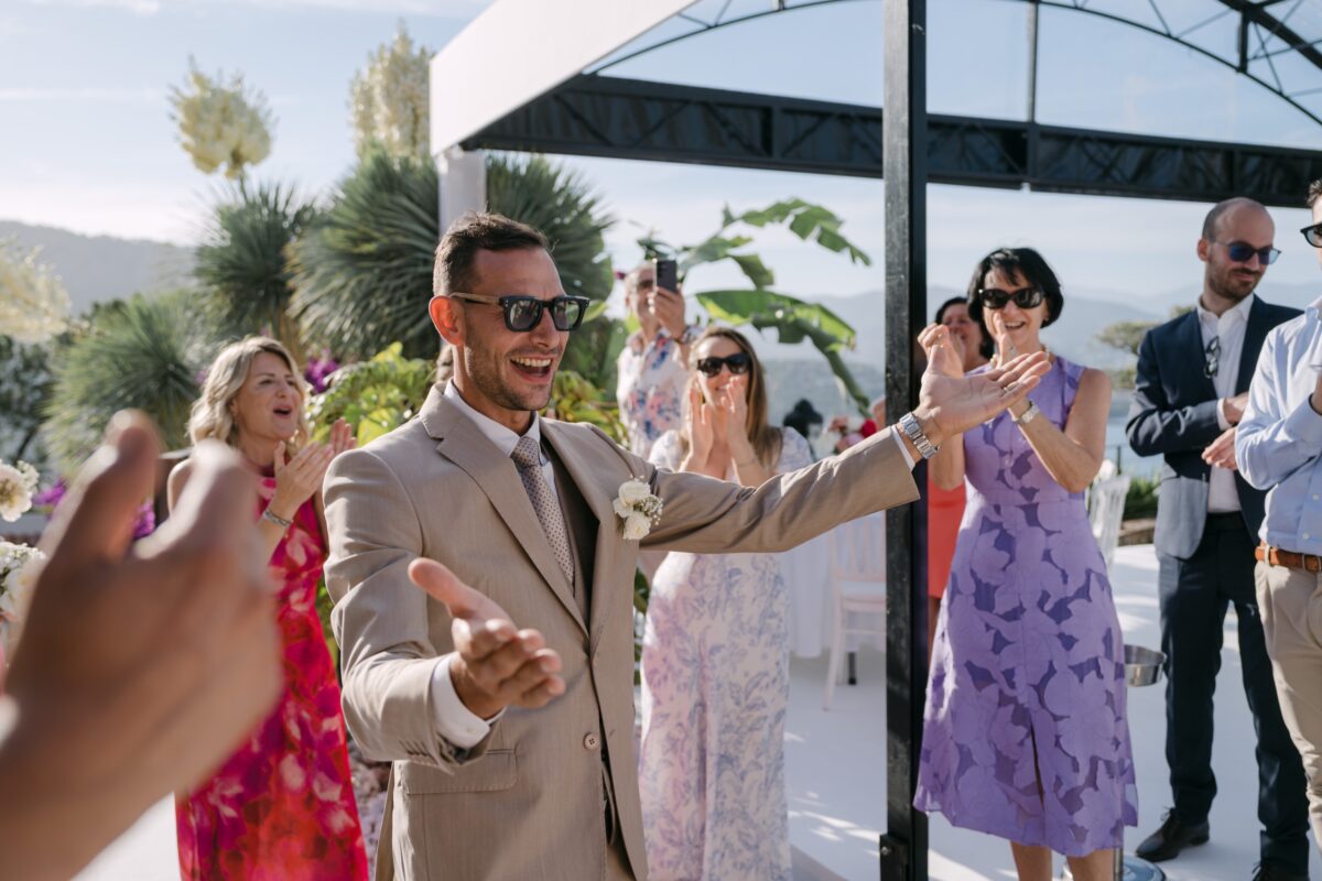 Le marié danse avec les invités sur une terrasse au-dessus de la mer