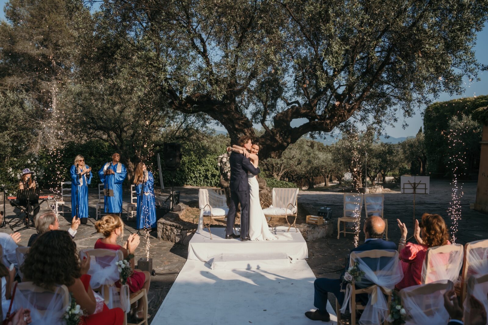 Un mariage en Provence en été : chaleur, lumière et photos 5 Cérémonie laïque à l'ombre d'un grand chêne, les invités assis de part et d'autre de l'allée