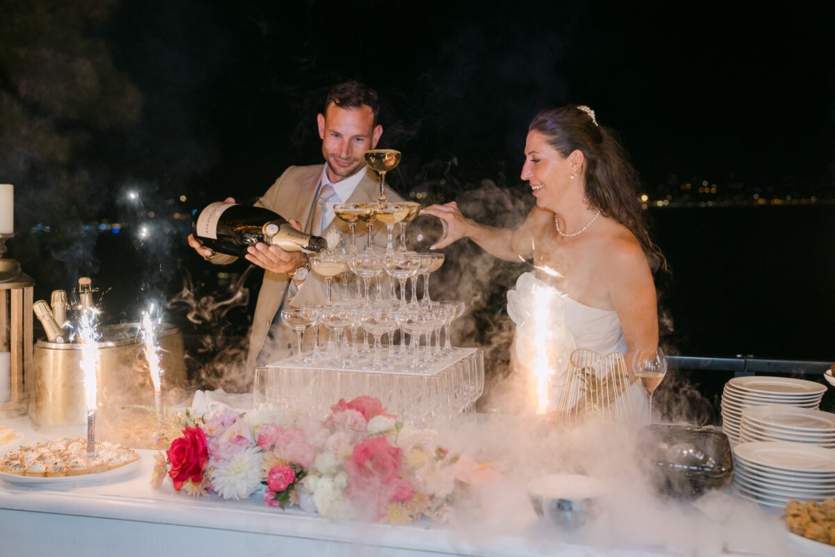 La nuit, les mariés versent le champagne sur une pyramide de coupes, entre les fontaines d'étincelles