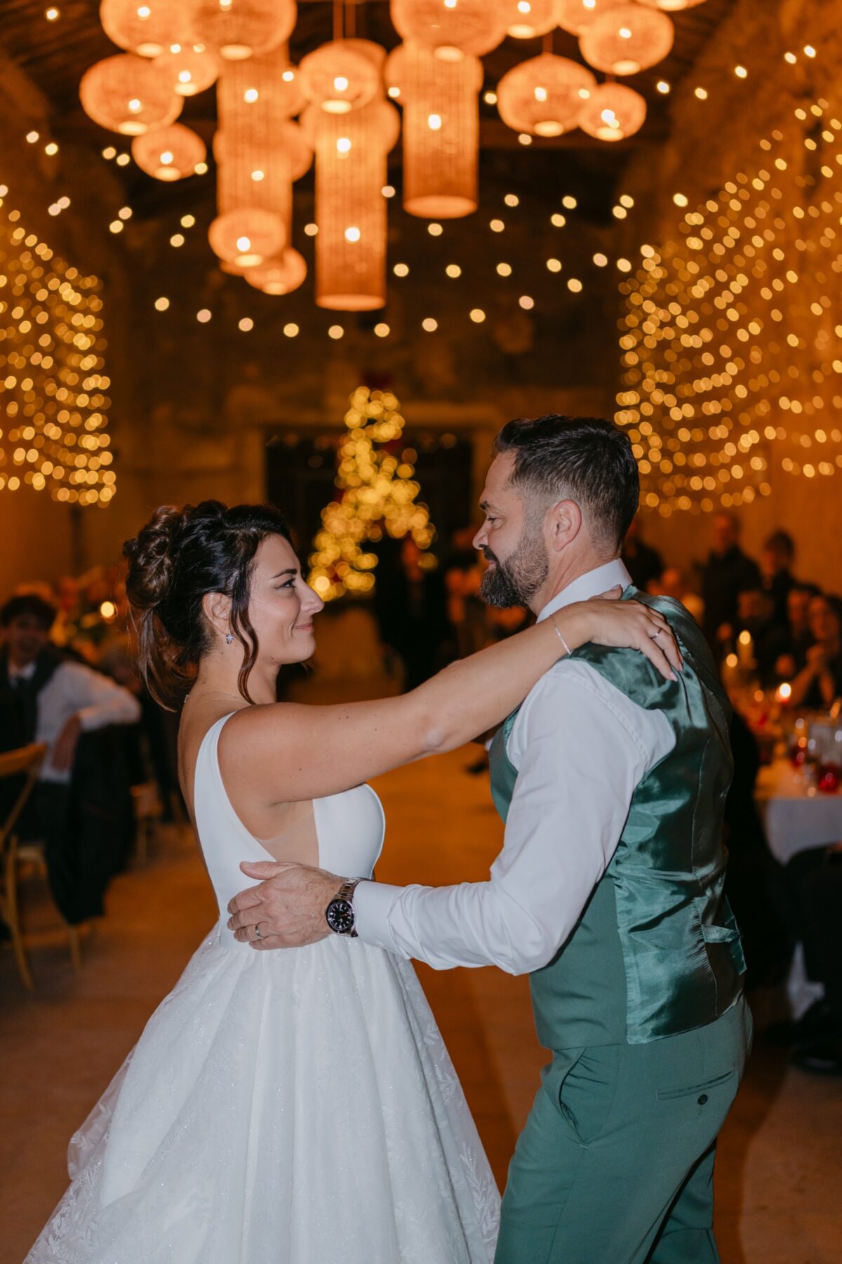 Mariage d'hiver : les mariés dansent sous des suspensions lumineuses orangées