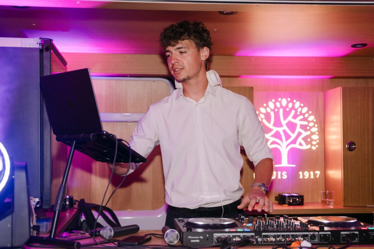 Le DJ aux platines sous une lumière rose, pendant la soirée