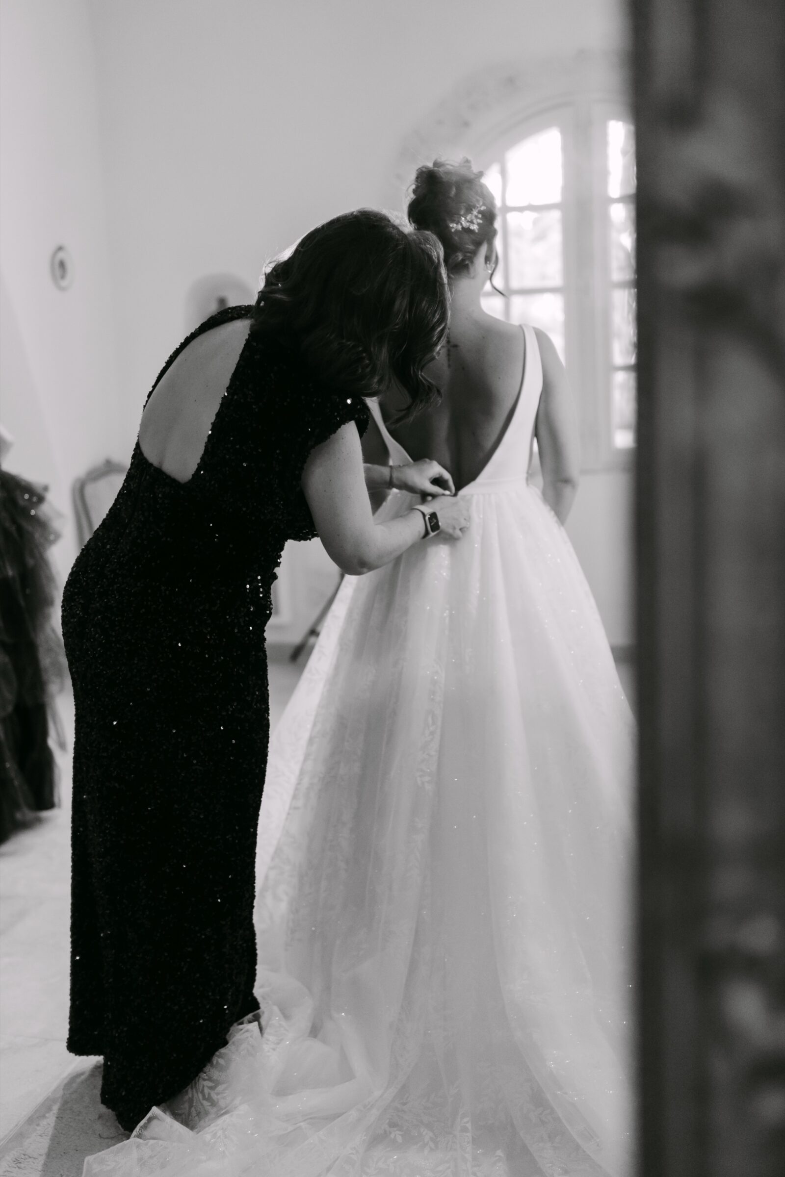 Photographe mariage Les Arcs 7 En noir et blanc, la mariée serre une proche dans ses bras
