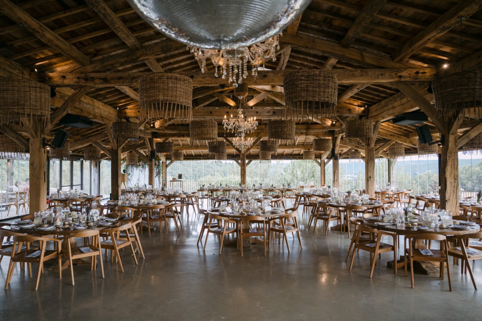 Photographe mariage Alpes-de-Haute-Provence 5 Grande halle en bois ouverte, tables rondes dressées sous une boule à facettes