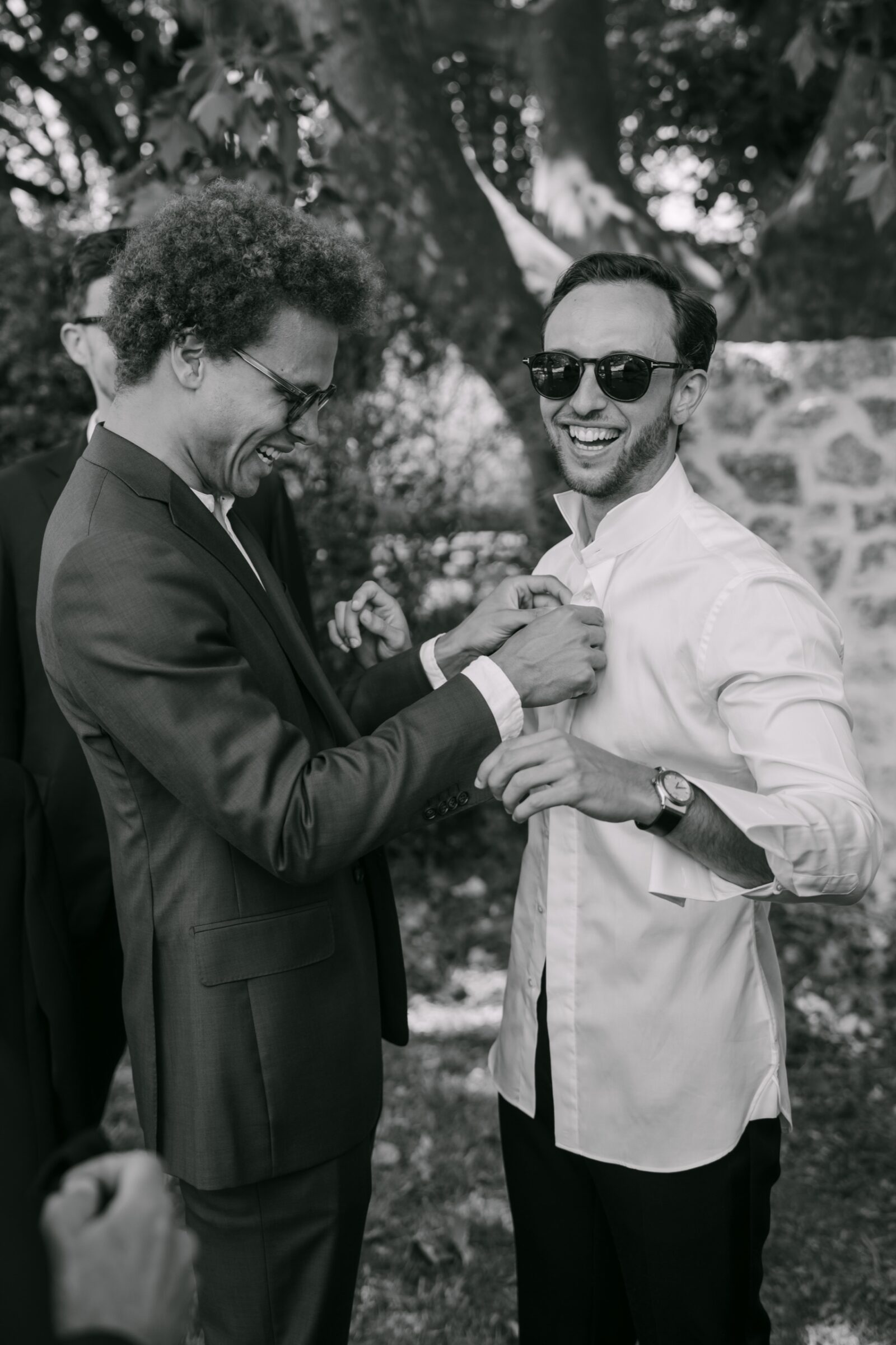 Photographe mariage Grimaud 6 En noir et blanc, deux amis du marié rient en ajustant leurs costumes