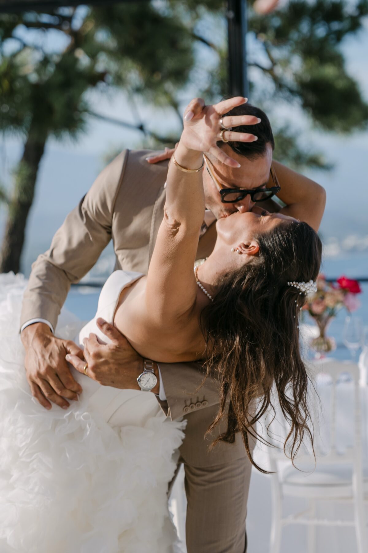 Sur une terrasse face à la mer, le marié fait basculer la mariée pour l'embrasser